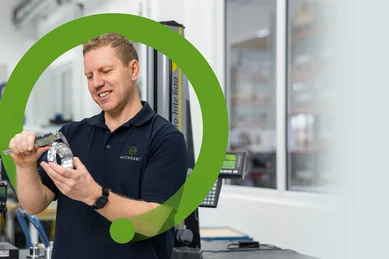 Ein Mitarbeiter der Qualitätssicherung misst ein Bauteil mit einem Messschieber