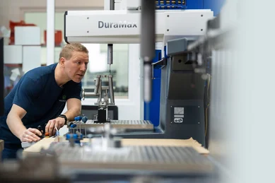 Ein Mitarbeiter der Qualitätssicherung bedient eine Messmaschine