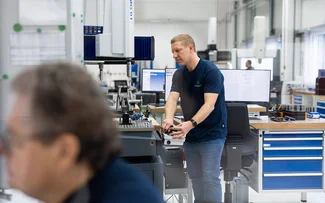 Ein Mitarbeiter der Qualitätssicherung bedient eine Messmaschine