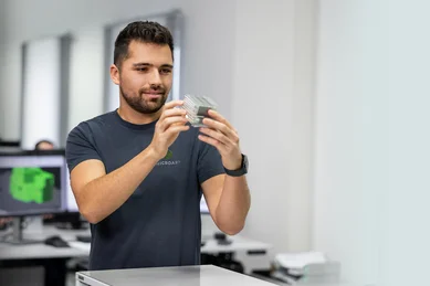 Ein Programmierer begutachtet ein Bauteil